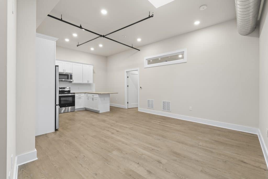 Loft at Lofts on Broad, Souderton with white kitchen, stainless appliances, wood floors and exposed ductwork.